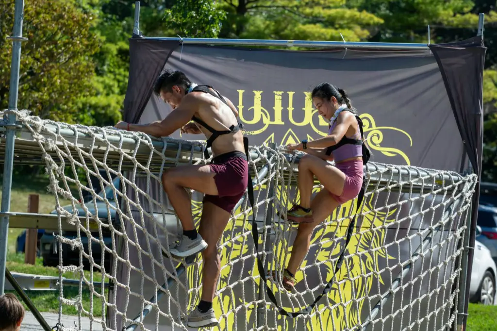 Participants climbing a cargo-net obstacle at Zulu Challenge